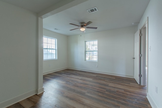 unfurnished room featuring ceiling fan, plenty of natural light, and dark wood-type flooring