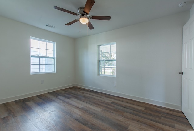 spare room with ceiling fan, a healthy amount of sunlight, and dark hardwood / wood-style floors