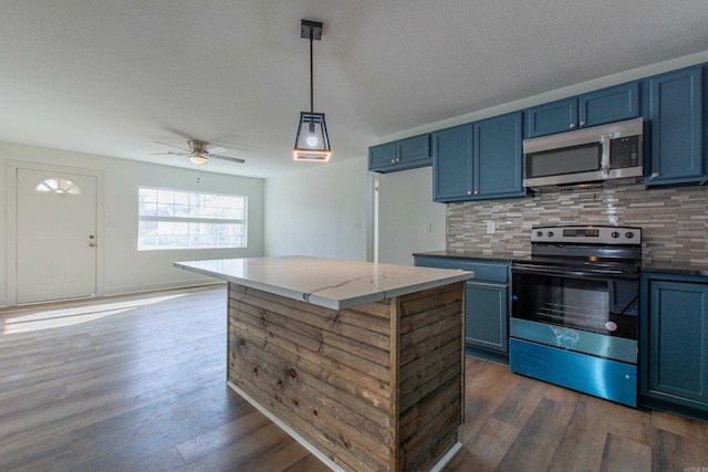 kitchen featuring decorative backsplash, stainless steel appliances, blue cabinets, ceiling fan, and pendant lighting