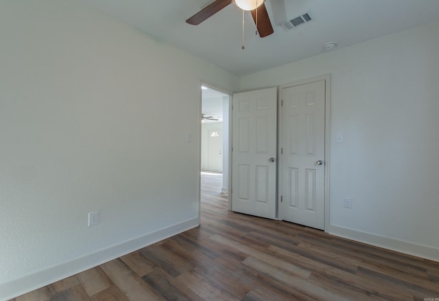 unfurnished bedroom with a closet, ceiling fan, and dark hardwood / wood-style flooring