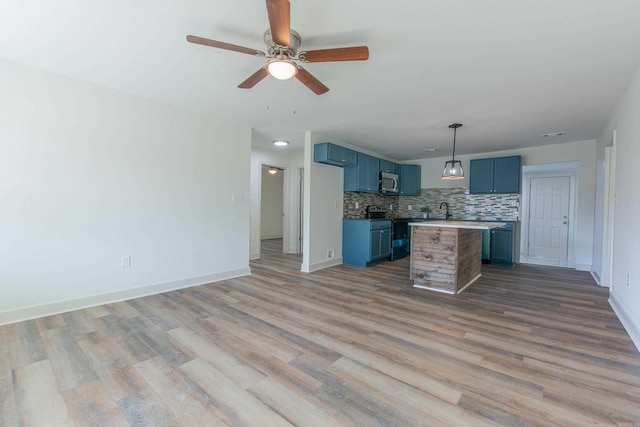 kitchen with sink, a center island, electric range oven, blue cabinets, and backsplash