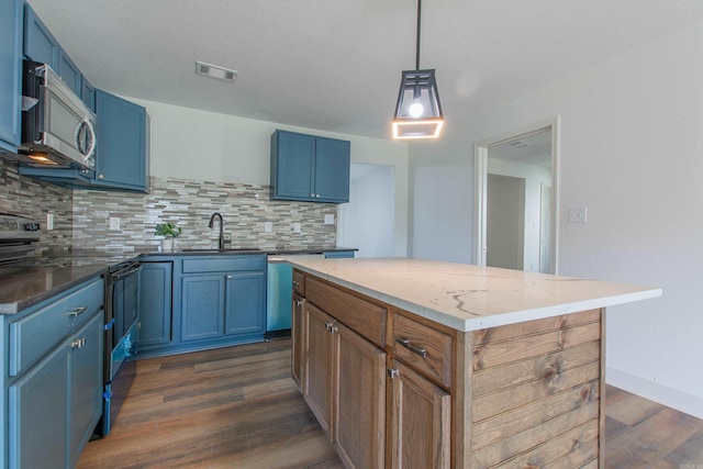 kitchen featuring decorative backsplash, blue cabinets, and appliances with stainless steel finishes