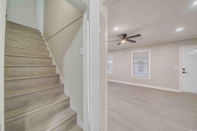 stairway featuring ceiling fan, hardwood / wood-style flooring, and ornamental molding