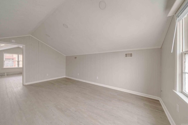 bonus room with hardwood / wood-style flooring and vaulted ceiling