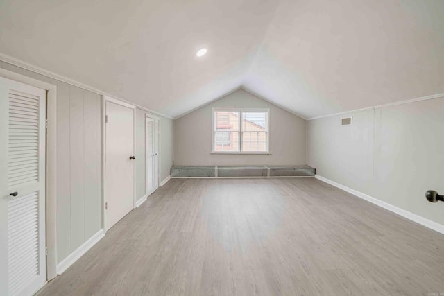 additional living space with light hardwood / wood-style flooring and vaulted ceiling