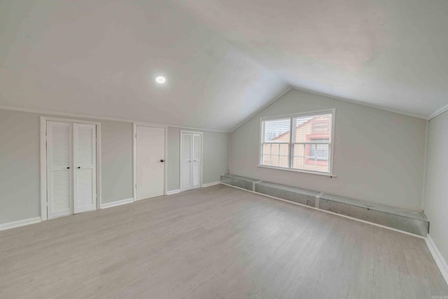 additional living space featuring light hardwood / wood-style flooring and lofted ceiling