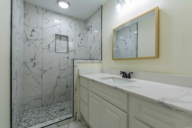 bathroom featuring a tile shower and vanity