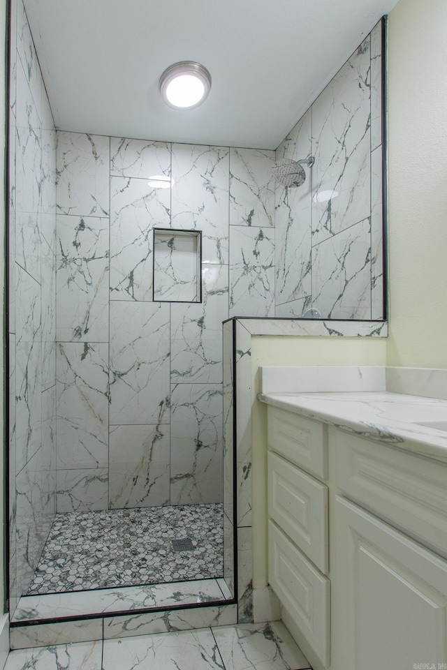 bathroom with vanity and tiled shower