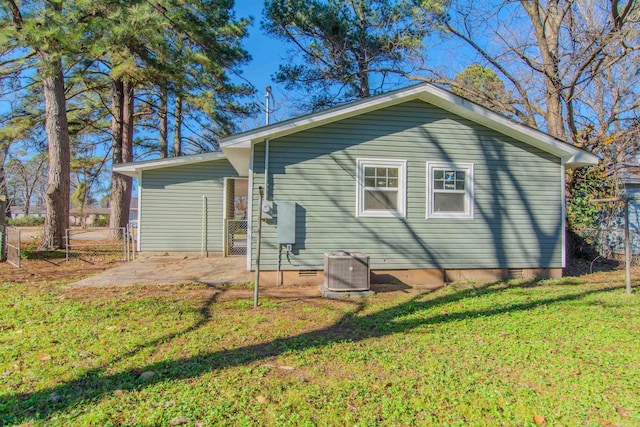 back of house featuring central AC, a patio area, and a lawn