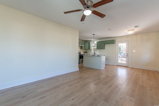 unfurnished living room featuring ceiling fan and light hardwood / wood-style floors