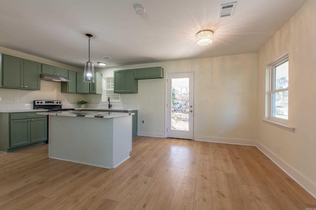 kitchen featuring an inviting chandelier, white range with electric cooktop, hanging light fixtures, green cabinetry, and light hardwood / wood-style floors