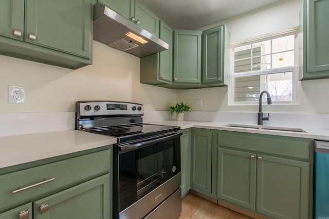 kitchen with light wood-type flooring, sink, appliances with stainless steel finishes, and green cabinetry