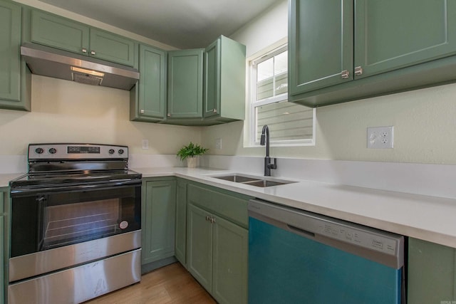 kitchen with green cabinets, sink, light hardwood / wood-style flooring, and appliances with stainless steel finishes