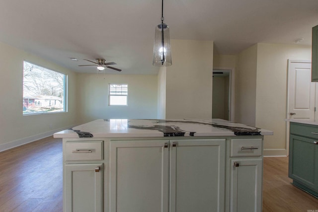 kitchen featuring a center island, white cabinets, pendant lighting, and light wood-type flooring