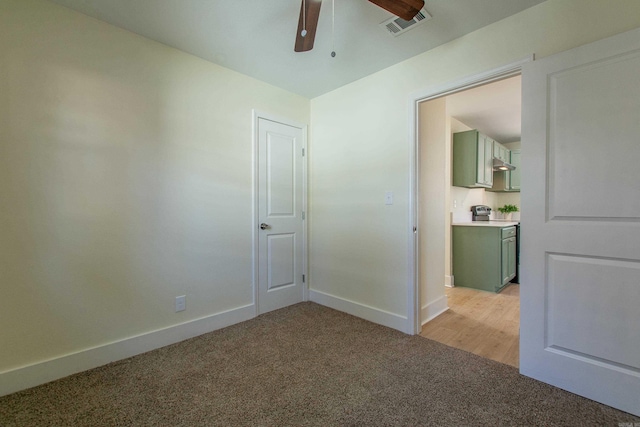 unfurnished room featuring light carpet and ceiling fan