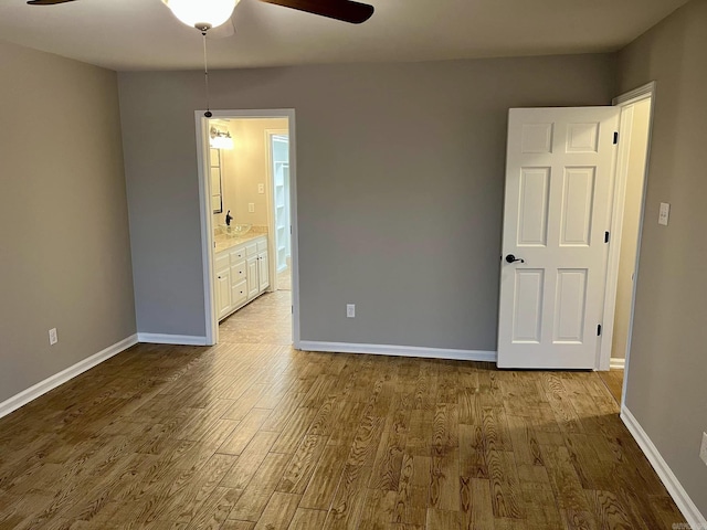 unfurnished bedroom featuring ceiling fan, light wood-type flooring, and ensuite bathroom