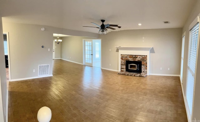 unfurnished living room featuring wood-type flooring and ceiling fan with notable chandelier