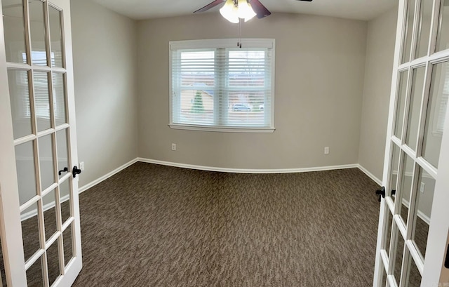 empty room with dark colored carpet, ceiling fan, and french doors