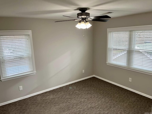 spare room with dark colored carpet and ceiling fan