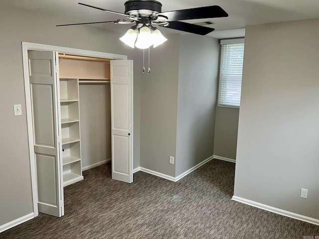 unfurnished bedroom with ceiling fan, a closet, and dark colored carpet