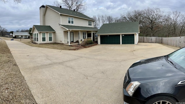 view of side of property with an outbuilding, covered porch, and a garage