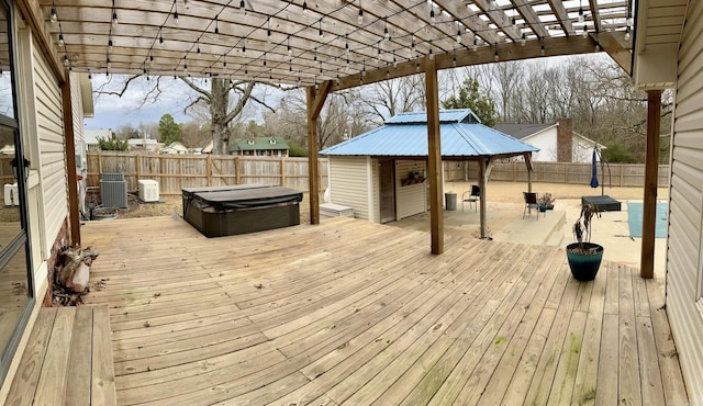 deck featuring a gazebo, a hot tub, and central AC unit