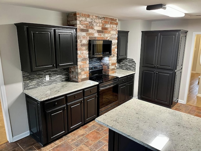 kitchen featuring light stone countertops, black range with electric cooktop, and backsplash