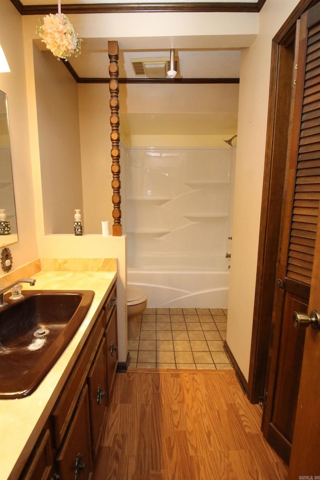 full bathroom with crown molding, shower / bath combination, wood-type flooring, toilet, and vanity