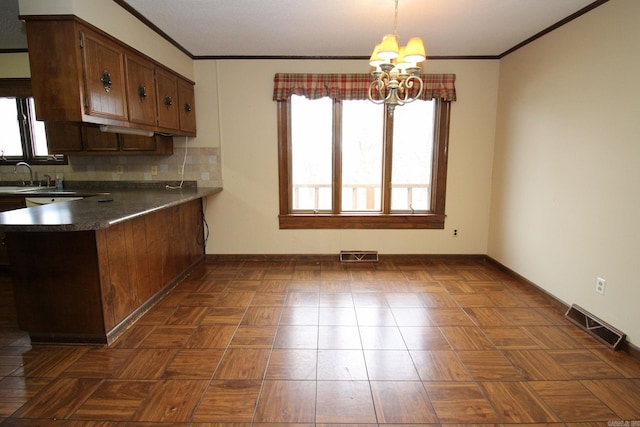 kitchen with dark parquet floors, sink, decorative light fixtures, tasteful backsplash, and a notable chandelier