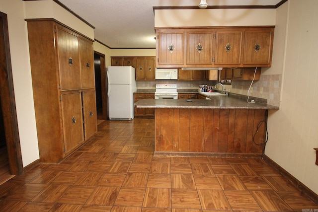 kitchen with dark parquet floors, decorative backsplash, white appliances, and kitchen peninsula