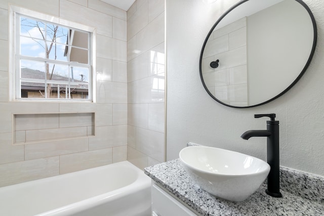 bathroom featuring tiled shower / bath combo and vanity