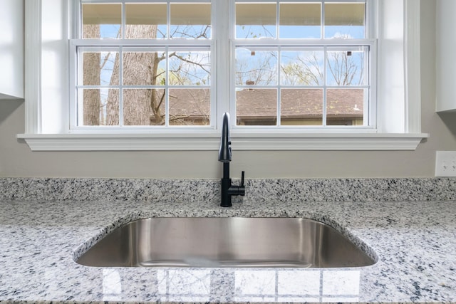 room details featuring light stone counters and sink