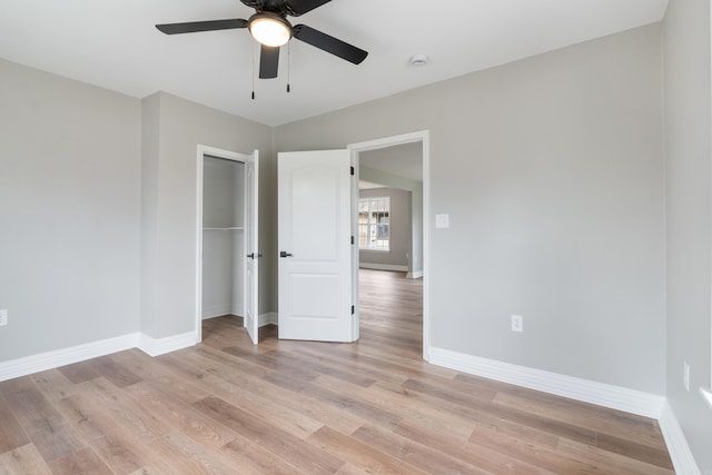 unfurnished bedroom with ceiling fan, light wood-type flooring, and a closet