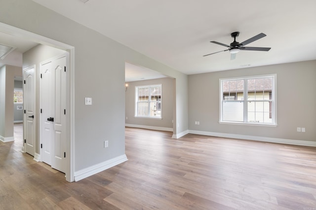 spare room featuring ceiling fan, light hardwood / wood-style floors, and plenty of natural light