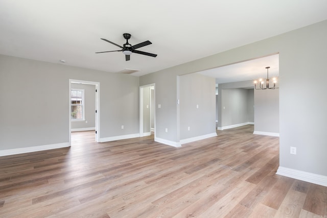 unfurnished room featuring ceiling fan with notable chandelier and light hardwood / wood-style floors