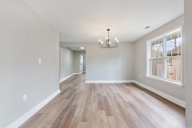 unfurnished dining area featuring light hardwood / wood-style floors and a notable chandelier