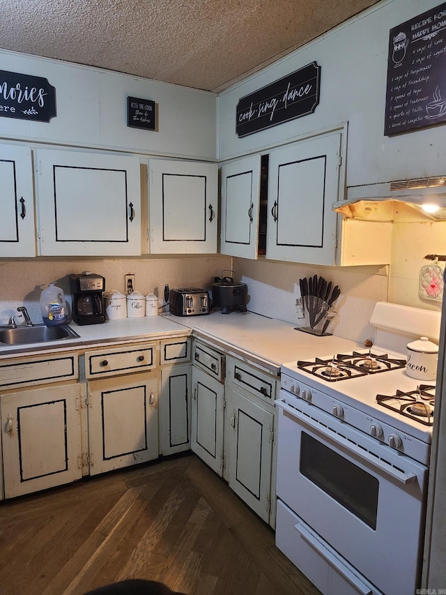 kitchen featuring white cabinetry, gas range gas stove, sink, dark hardwood / wood-style flooring, and a textured ceiling