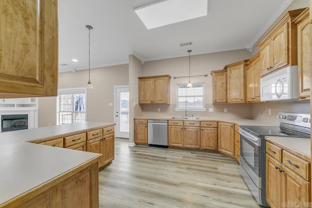 kitchen featuring appliances with stainless steel finishes, light wood-type flooring, ornamental molding, sink, and pendant lighting