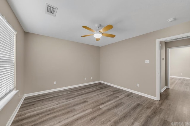 unfurnished room featuring wood-type flooring, ceiling fan, and a healthy amount of sunlight