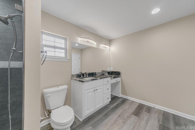 bathroom featuring toilet, vanity, and hardwood / wood-style flooring