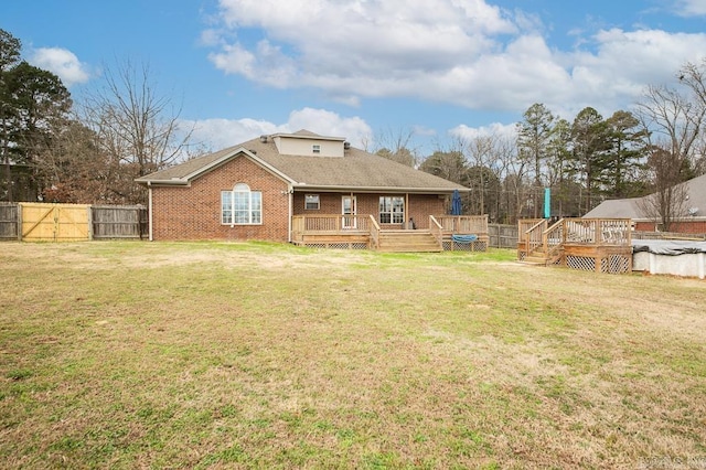 rear view of house with a yard, a pool side deck, and a trampoline