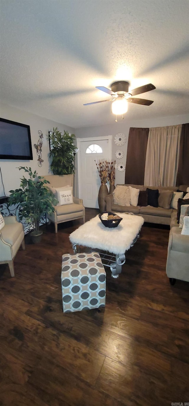 living room with ceiling fan, dark hardwood / wood-style flooring, and a textured ceiling