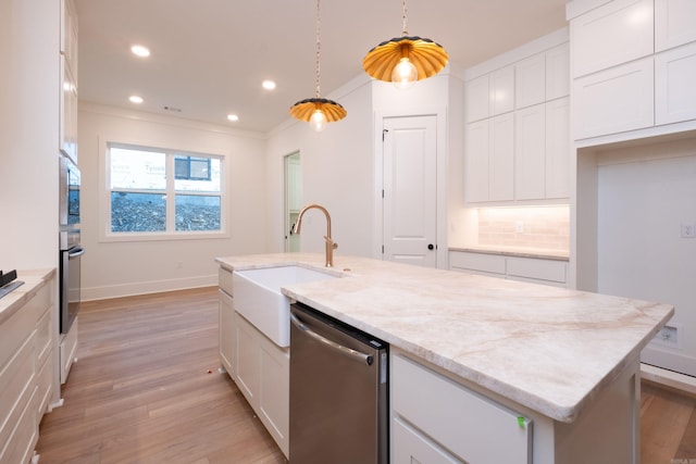 kitchen with appliances with stainless steel finishes, decorative light fixtures, light stone countertops, and white cabinets