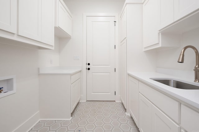 kitchen with white cabinetry, sink, and light tile patterned floors