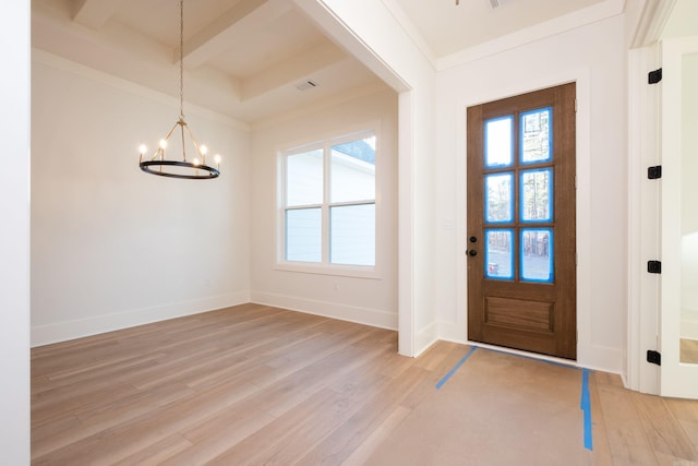 foyer with beamed ceiling, plenty of natural light, an inviting chandelier, and light hardwood / wood-style floors