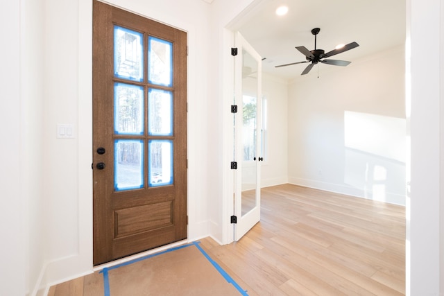 entrance foyer with ornamental molding, light wood-type flooring, a wealth of natural light, and ceiling fan