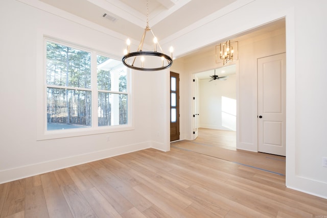 unfurnished dining area featuring crown molding, ceiling fan with notable chandelier, and light wood-type flooring