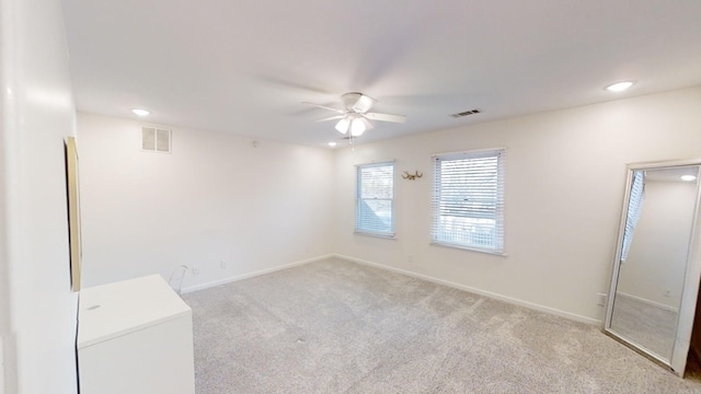 empty room with ceiling fan and light colored carpet