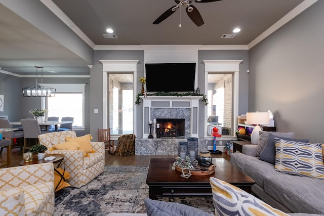 living room featuring ceiling fan, hardwood / wood-style floors, a high end fireplace, and ornamental molding