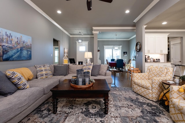 living room featuring ceiling fan with notable chandelier, hardwood / wood-style flooring, and crown molding